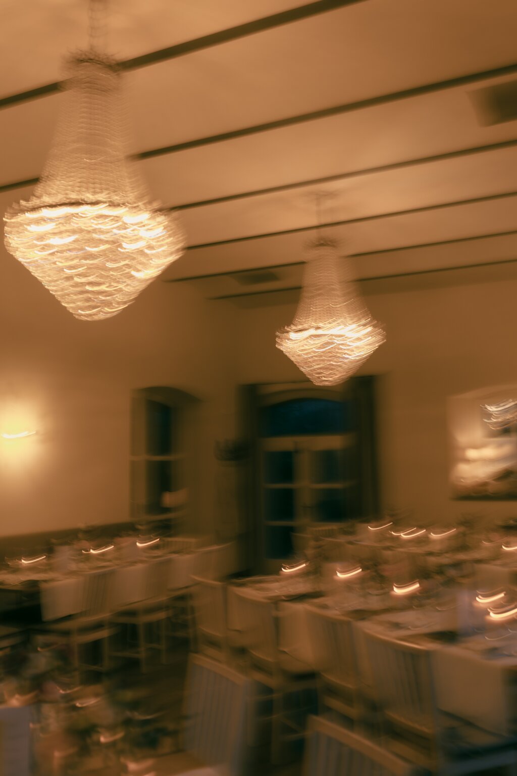 Abendliches Szenario einer Hochzeitslocation. Brennende Kerzen und Kronleuchter.